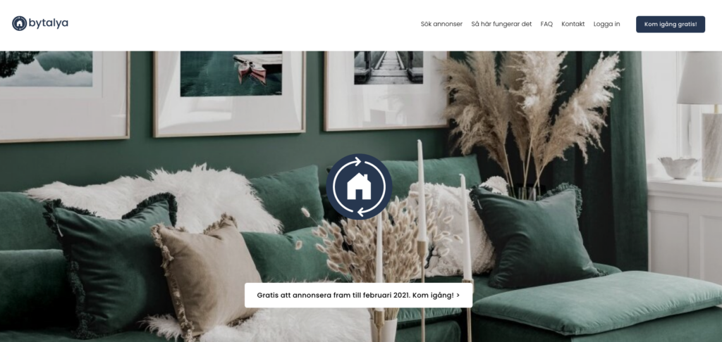 Skärpdump på Bytalya 's hemsida. Förställer ett vardagsrum, en grön soffa med beige och vita kuddar. Mitt på bilden är det en husikon.